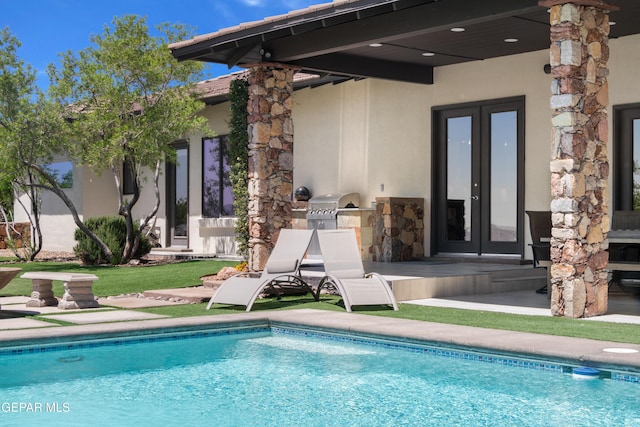 pool featuring french doors, exterior kitchen, and a patio area