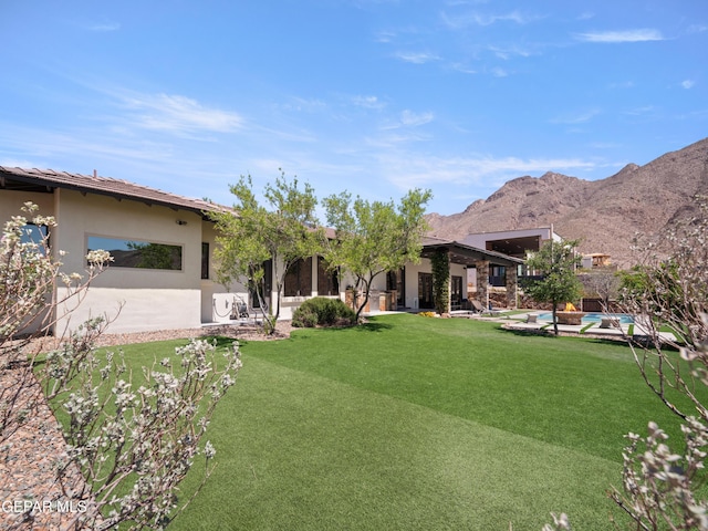 view of yard with a mountain view, a patio area, and an outdoor pool