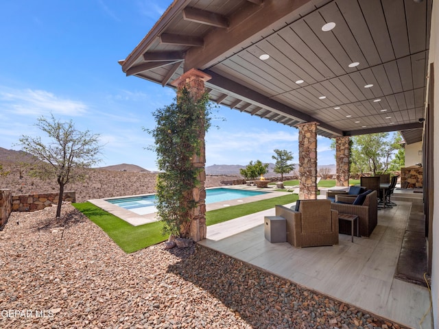 view of patio / terrace with an outdoor pool, a mountain view, and an outdoor hangout area