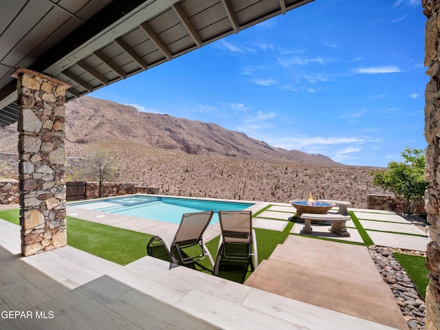 view of pool featuring a fenced backyard, a fenced in pool, a mountain view, and a patio area