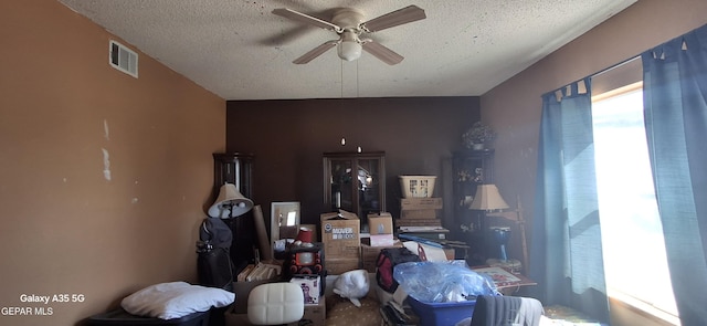 interior space featuring visible vents, a ceiling fan, and a textured ceiling