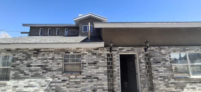 doorway to property with brick siding