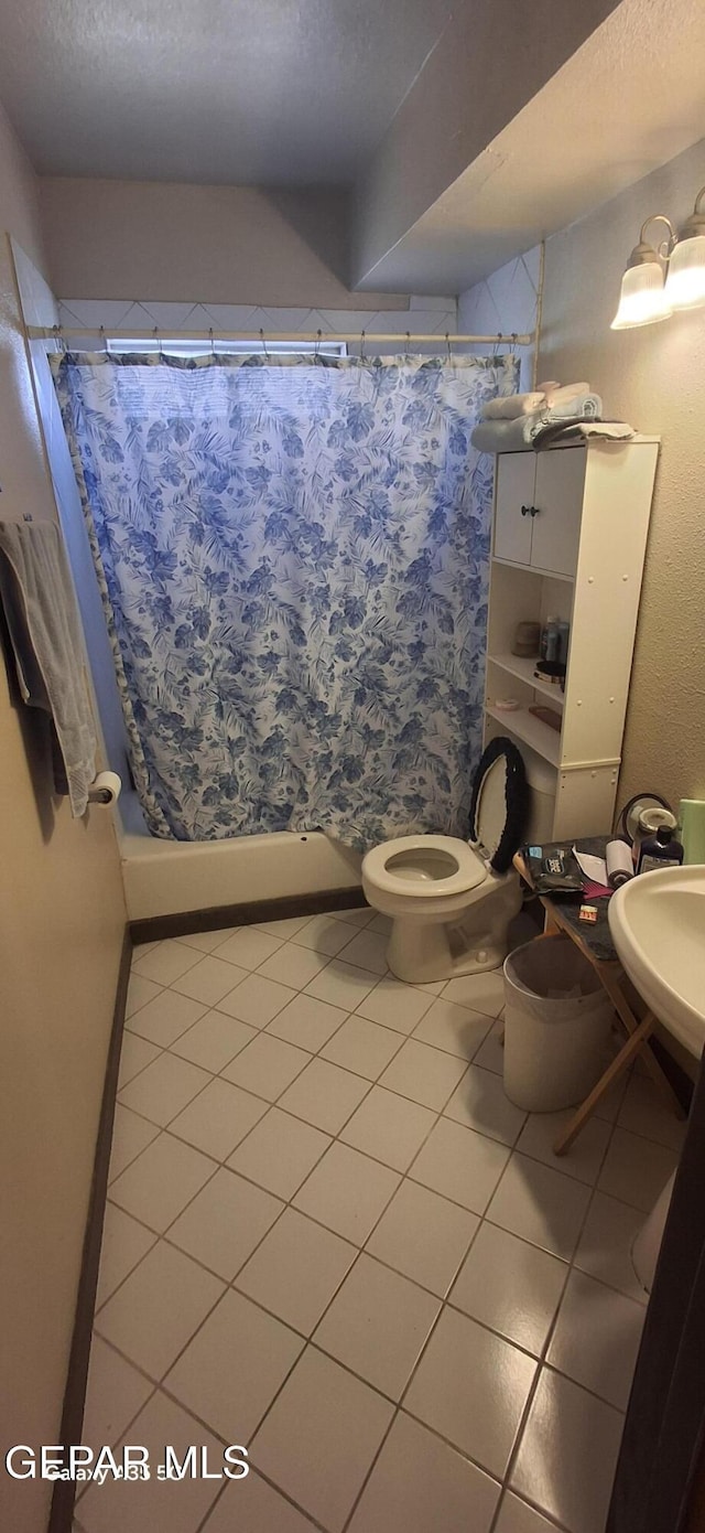 full bath featuring toilet, tile patterned floors, a sink, and curtained shower