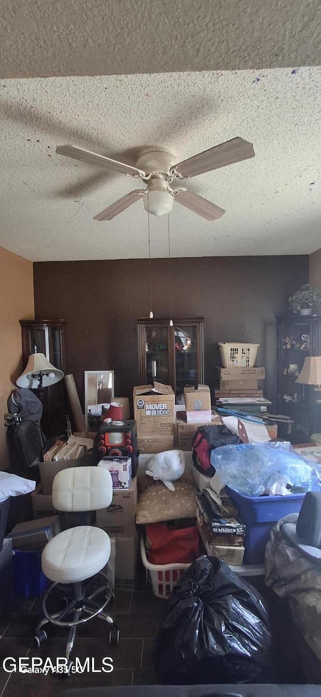 interior space featuring a ceiling fan and a textured ceiling