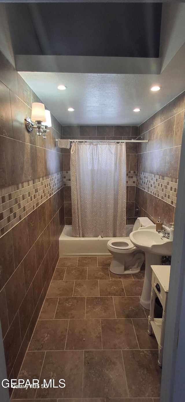 full bathroom featuring toilet, tiled shower / bath combo, tile walls, and recessed lighting
