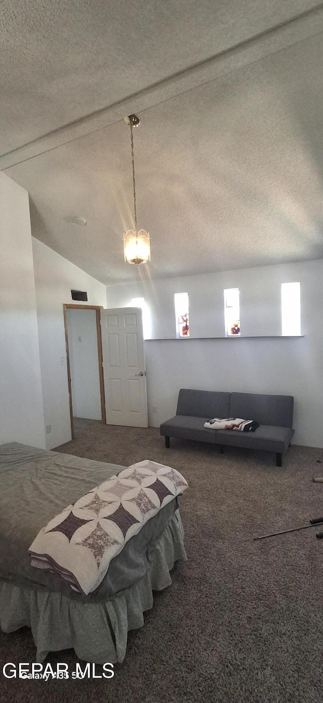 bedroom featuring a textured ceiling, vaulted ceiling, and carpet