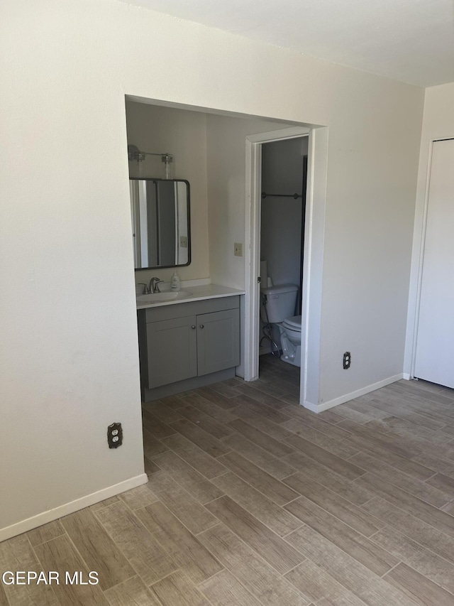 2816 Gaston Dr, El Paso, TX 79935 - bathroom featuring toilet, vanity, wood finished floors, and baseboards