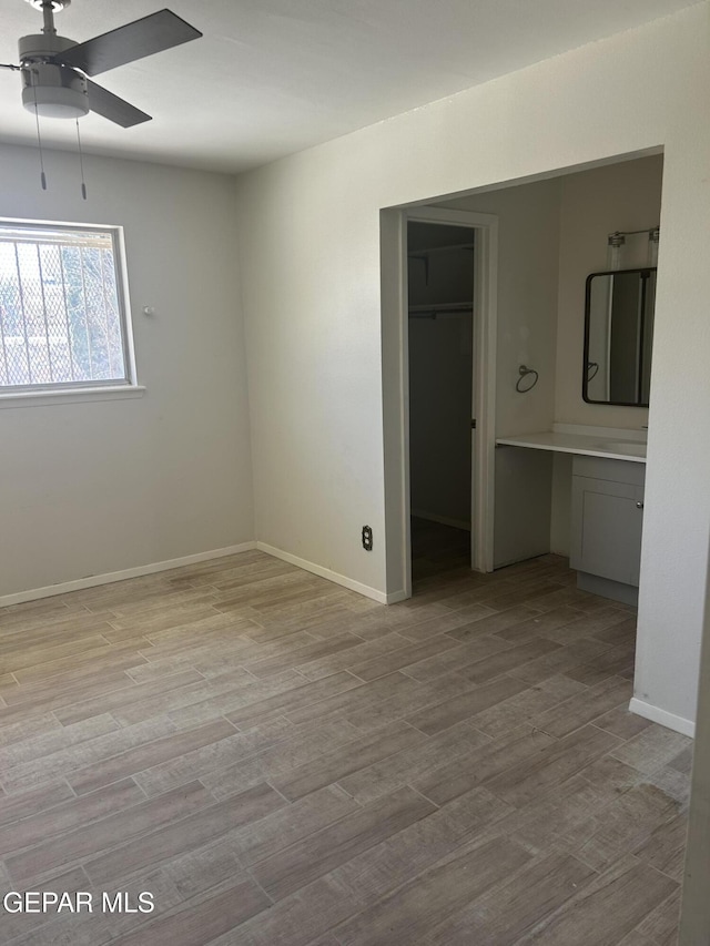 2816 Gaston Dr, El Paso, TX 79935 - unfurnished bedroom featuring a closet, wood finished floors, baseboards, a spacious closet, and a ceiling fan