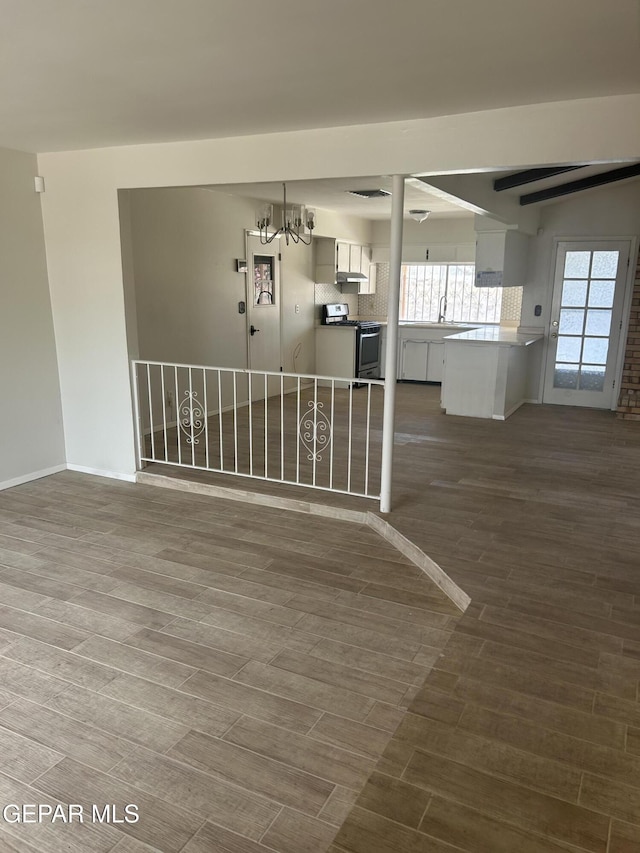 2816 Gaston Dr, El Paso, TX 79935 - unfurnished room with dark wood-style floors, a chandelier, baseboards, and a sink