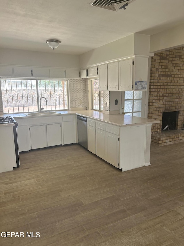 2816 Gaston Dr, El Paso, TX 79935 - kitchen featuring dishwasher, a sink, white cabinetry, and wood finished floors