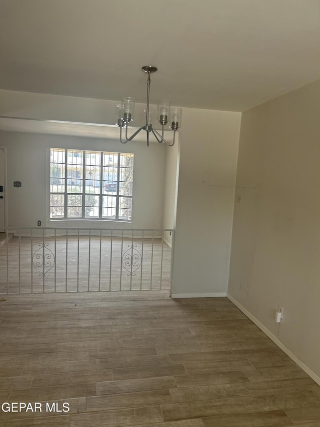 2816 Gaston Dr, El Paso, TX 79935 - empty room featuring a chandelier, wood finished floors, and baseboards