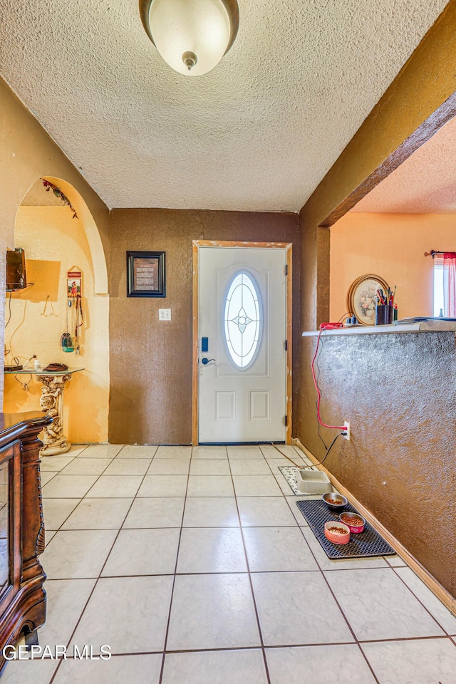 foyer entrance featuring light tile patterned floors and a textured ceiling