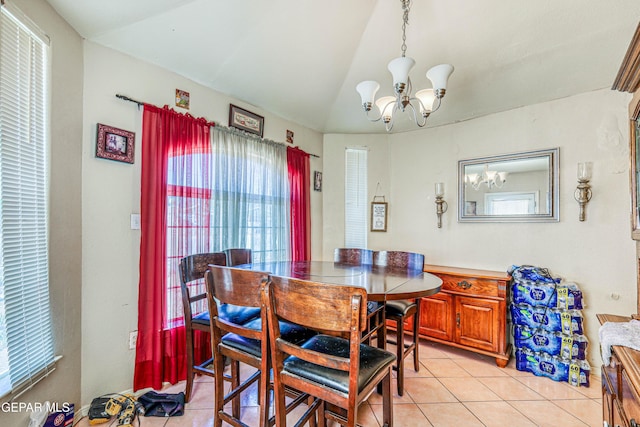 dining room with light tile patterned floors, a notable chandelier, and vaulted ceiling