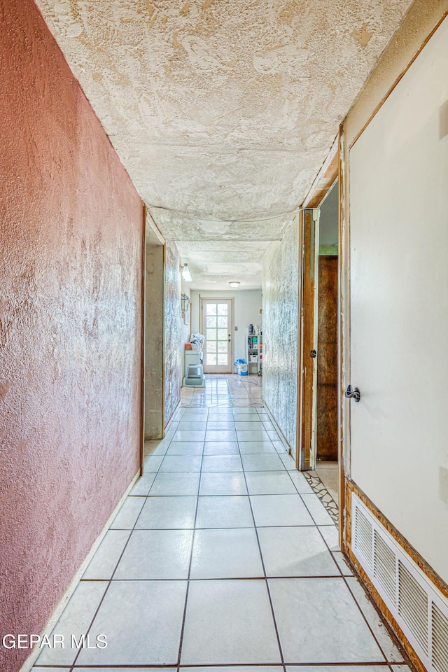 corridor featuring light tile patterned floors and visible vents