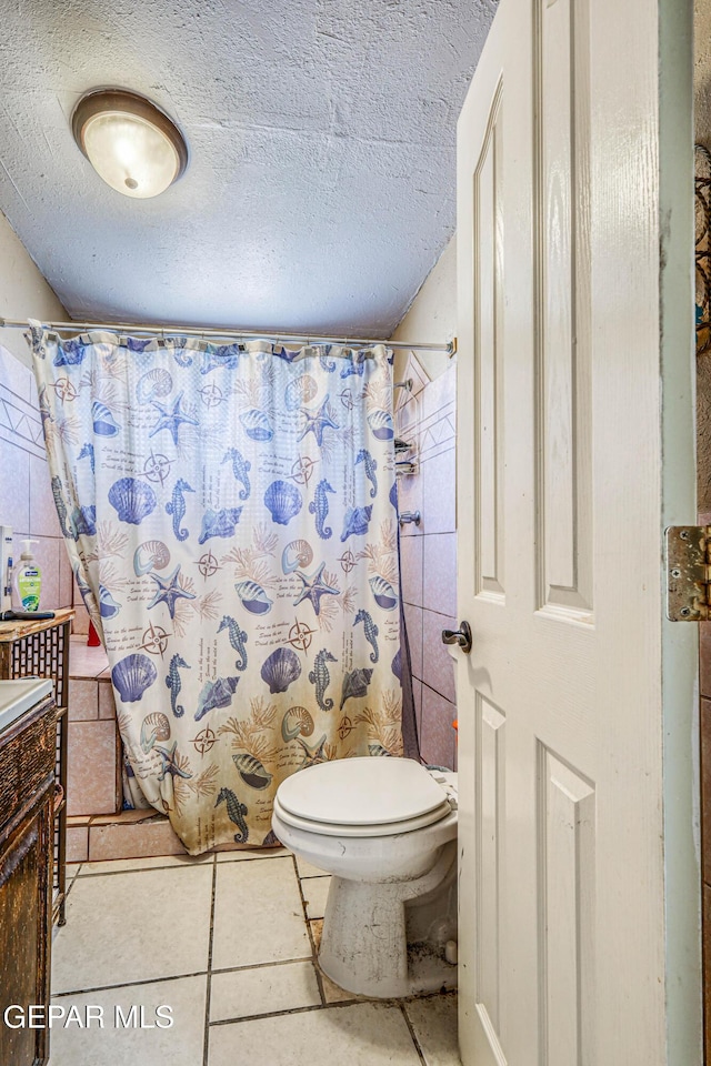 full bathroom with vanity, tile patterned floors, a textured ceiling, a shower with curtain, and toilet