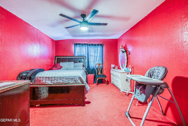 carpeted bedroom with a ceiling fan, a textured wall, and a textured ceiling