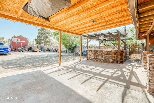 view of patio with a trampoline, outdoor dry bar, a pergola, fence, and a playground