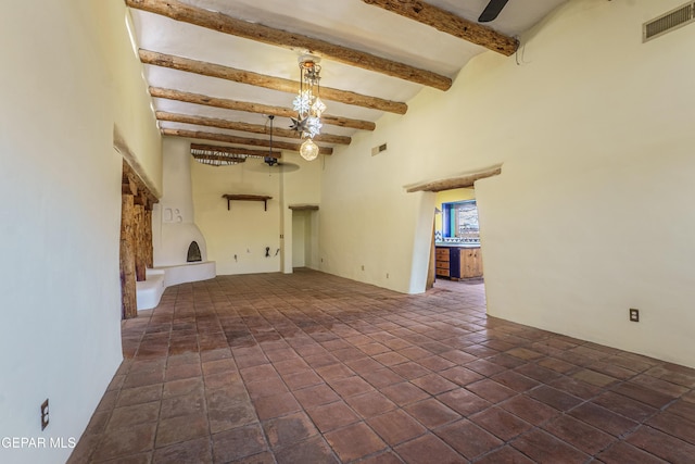 32 Cielo Dorado Dr, Anthony, NM 88021 - unfurnished living room featuring a towering ceiling, visible vents, and beam ceiling