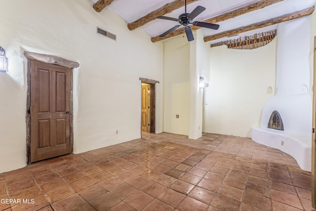 32 Cielo Dorado Dr, Anthony, NM 88021 - empty room with ceiling fan, stone tile floors, visible vents, a high ceiling, and beam ceiling