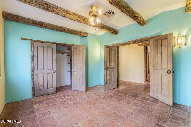 32 Cielo Dorado Dr, Anthony, NM 88021 - unfurnished bedroom featuring beamed ceiling, ceiling fan, visible vents, and stone tile flooring
