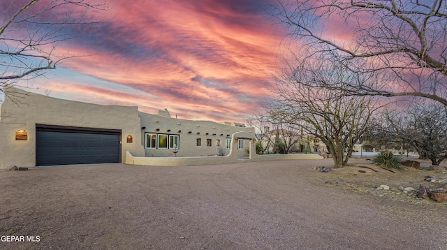 32 Cielo Dorado Dr, Anthony, NM 88021 - pueblo-style home with an attached garage and dirt driveway