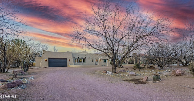 32 Cielo Dorado Dr, Anthony, NM 88021 - southwest-style home featuring stucco siding, an attached garage, and dirt driveway