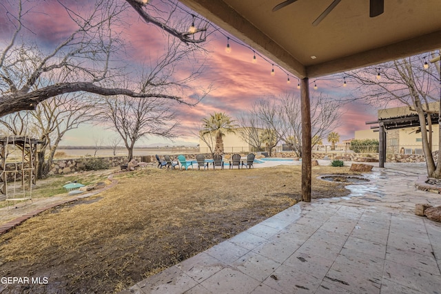32 Cielo Dorado Dr, Anthony, NM 88021 - yard at dusk featuring a fenced in pool, a patio area, and a ceiling fan