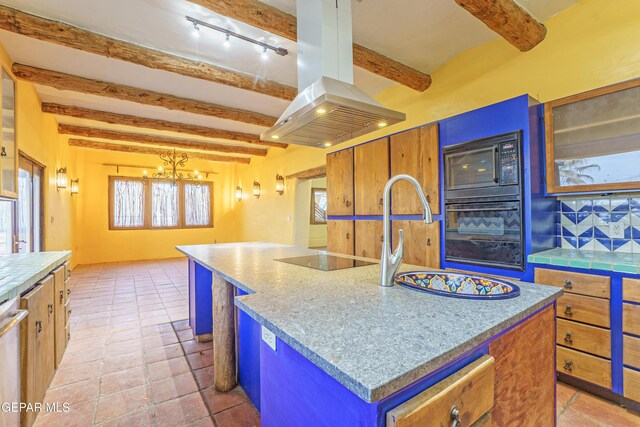 32 Cielo Dorado Dr, Anthony, NM 88021 - kitchen with a center island, beamed ceiling, black appliances, island range hood, and decorative backsplash