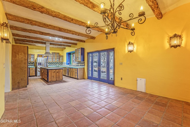 32 Cielo Dorado Dr, Anthony, NM 88021 - kitchen featuring beamed ceiling, glass insert cabinets, a center island, appliances with stainless steel finishes, and backsplash