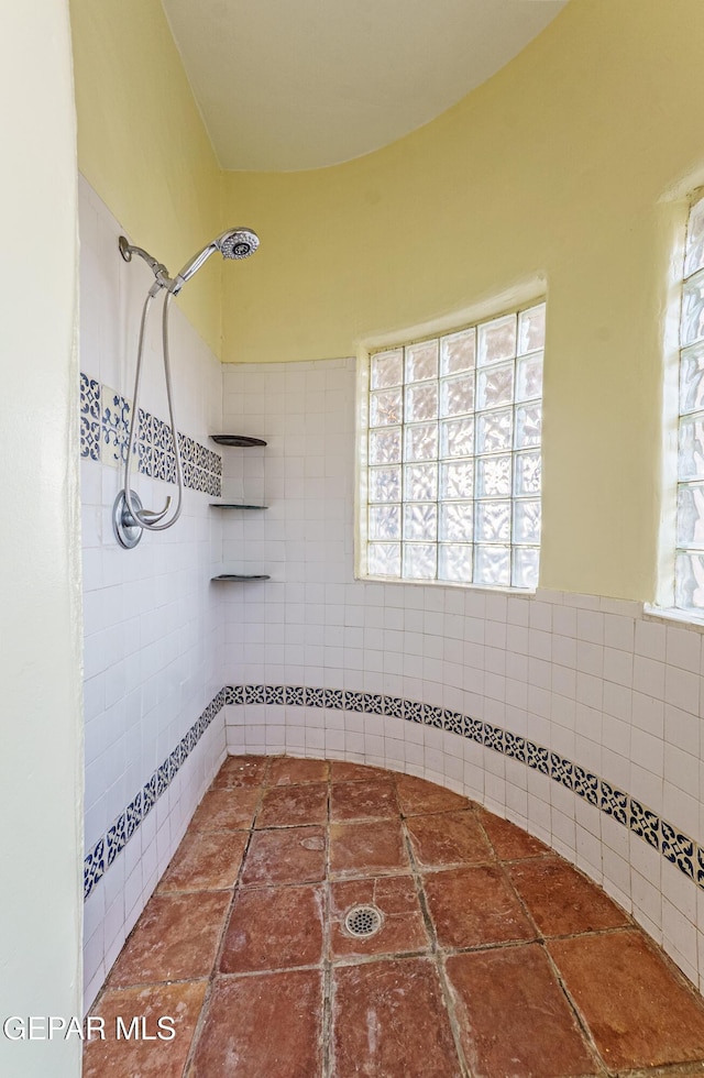32 Cielo Dorado Dr, Anthony, NM 88021 - bathroom featuring tile walls and tiled shower