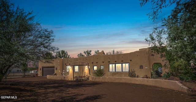 32 Cielo Dorado Dr, Anthony, NM 88021 - pueblo-style house featuring a garage, driveway, and stucco siding