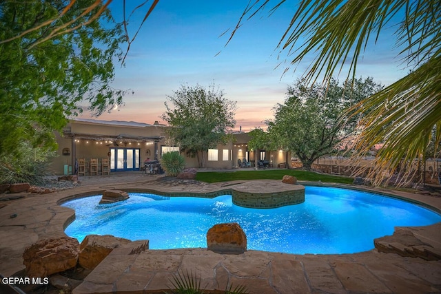 32 Cielo Dorado Dr, Anthony, NM 88021 - pool at dusk featuring an outdoor pool, a patio, and french doors