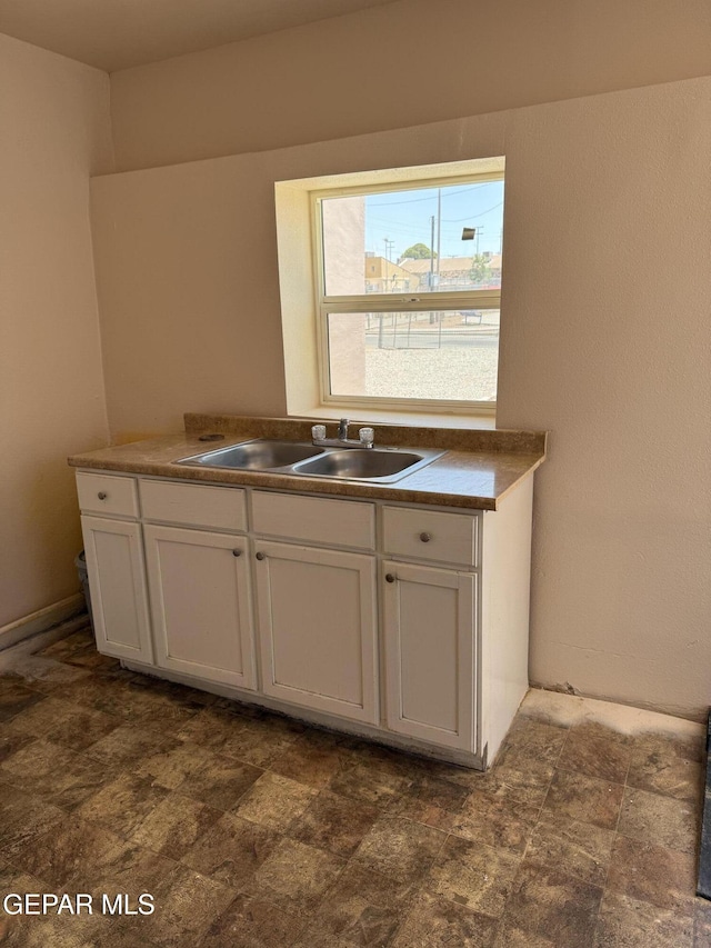 222 Lone Star Pl, El Paso, TX 79907 - kitchen with white cabinets, a sink, and dark stone finish flooring