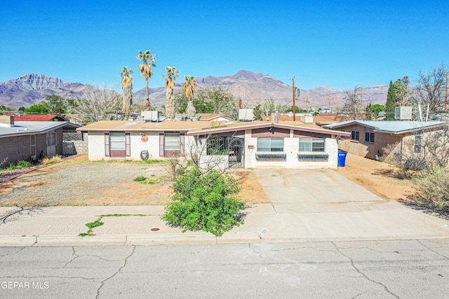 ranch-style house with a mountain view, cooling unit, and driveway