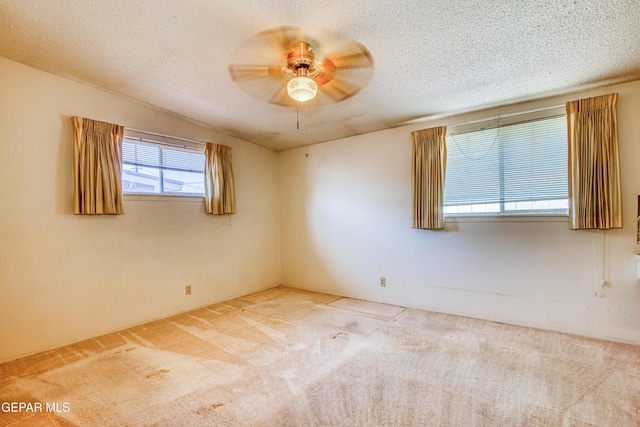 carpeted empty room with a textured ceiling and a ceiling fan