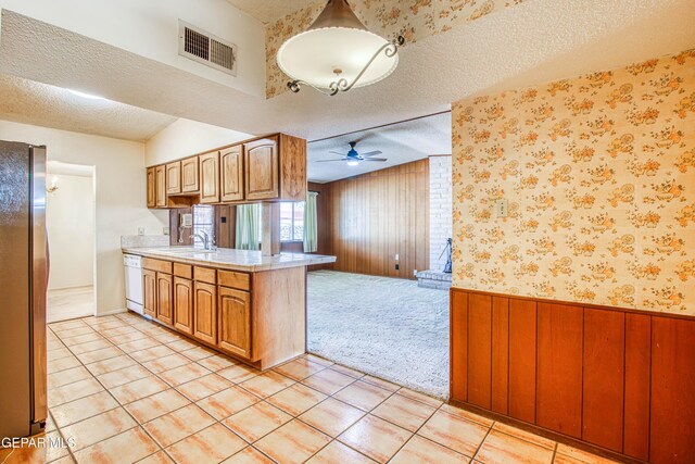 kitchen featuring visible vents, freestanding refrigerator, dishwasher, and a textured ceiling