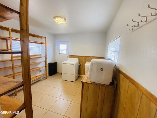 washroom with light tile patterned floors, wainscoting, and independent washer and dryer