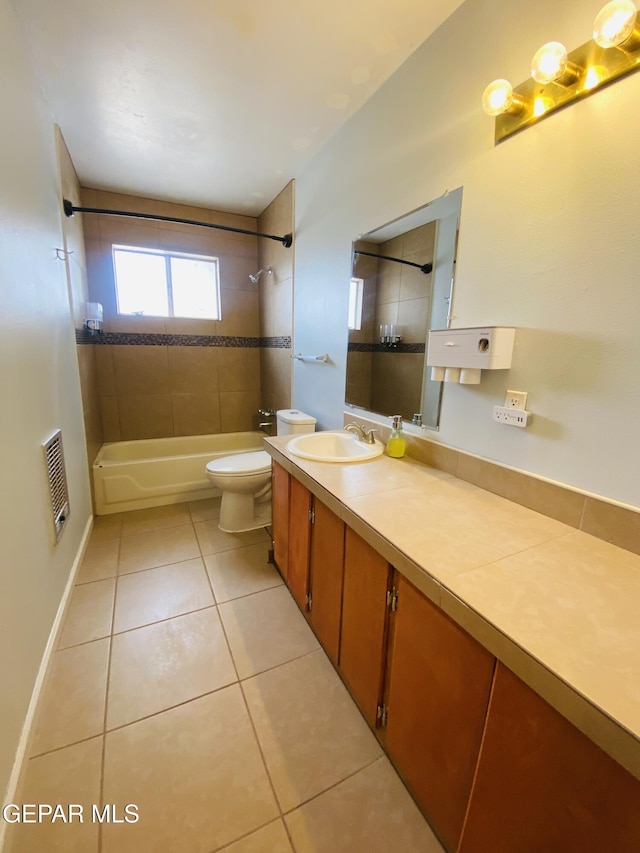 bathroom featuring washtub / shower combination, vanity, baseboards, tile patterned flooring, and toilet