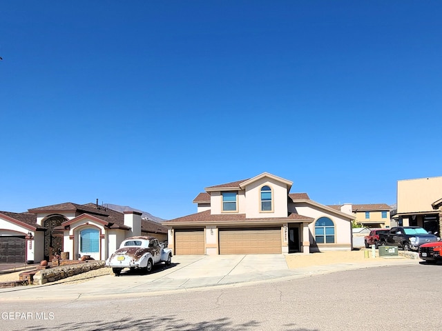 view of front of property with a garage, stucco siding, and driveway