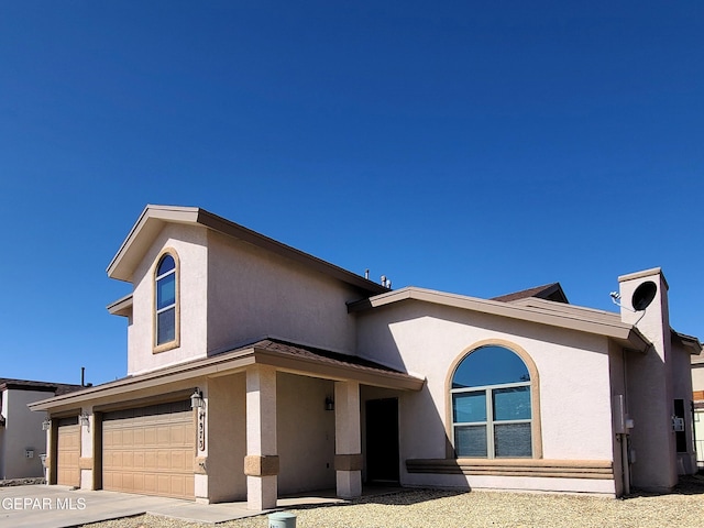 view of front of house with a garage, stucco siding, and concrete driveway