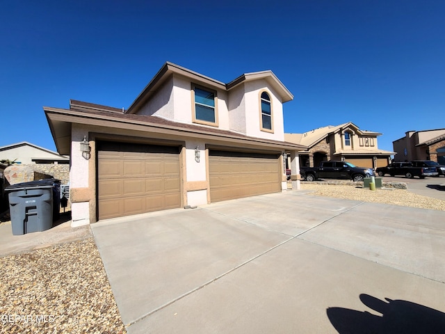 view of front facade featuring a garage, driveway, and stucco siding