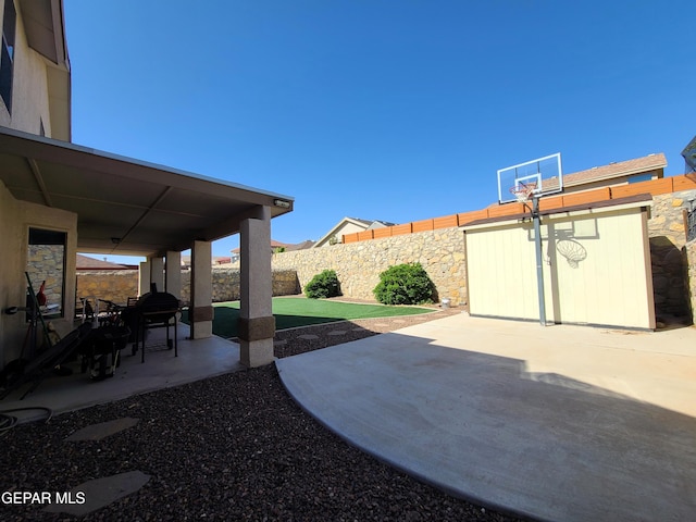 view of patio / terrace featuring a fenced backyard, a shed, and an outbuilding