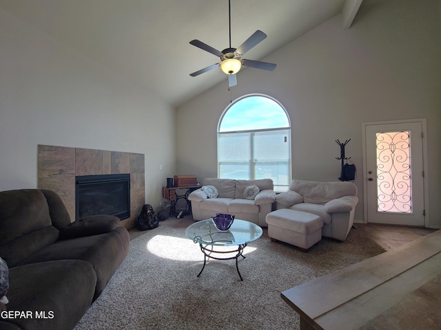 living room featuring a tiled fireplace, high vaulted ceiling, and a ceiling fan