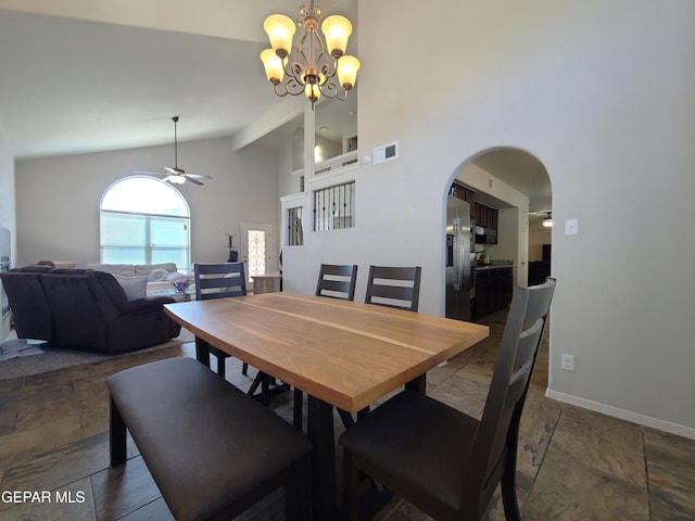 dining room featuring visible vents, arched walkways, baseboards, high vaulted ceiling, and ceiling fan with notable chandelier