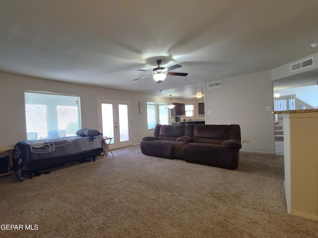 living room featuring visible vents, carpet flooring, and ceiling fan