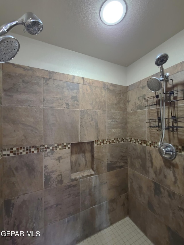 full bath featuring a textured ceiling and tiled shower