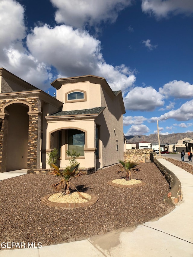 view of front of property featuring stucco siding and stone siding