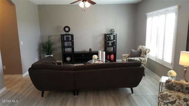 living room featuring plenty of natural light, ceiling fan, and baseboards