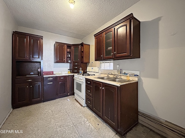 81 N Eucalyptus St, El Paso, TX 79901 - kitchen with baseboards, light countertops, dark brown cabinets, gas range gas stove, and a sink