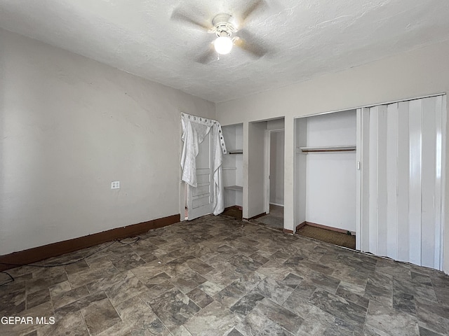 81 N Eucalyptus St, El Paso, TX 79901 - unfurnished bedroom featuring a textured ceiling, baseboards, stone finish flooring, and multiple closets